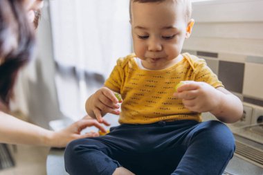 Anne bebeğini çevre dostu bir kesekağıdından taze üzümle besliyor, sürdürülebilirliği vurguluyor. Yüksek kalite fotoğraf
