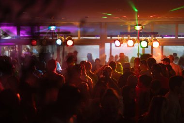 Elleri havada insanlar, diskoda, konser kalabalığının siluetleri parlak sahne ışıkları önünde. Yüksek kalite fotoğraf