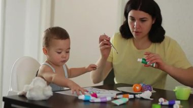 Erkek ve anne, Paskalya yumurtalarını birlikte süslüyor yaratıcı bir bağ anının tadını çıkarıyorlar. Paskalya, annelik ve yaratıcılık. Yüksek kalite 4k görüntü