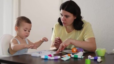 Erkek ve anne, Paskalya yumurtalarını birlikte süslüyor yaratıcı bir bağ anının tadını çıkarıyorlar. Paskalya, annelik ve yaratıcılık. Yüksek kalite 4k görüntü