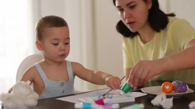 Erkek ve anne, Paskalya yumurtalarını birlikte süslüyor yaratıcı bir bağ anının tadını çıkarıyorlar. Paskalya, annelik ve yaratıcılık. Yüksek kalite 4k görüntü