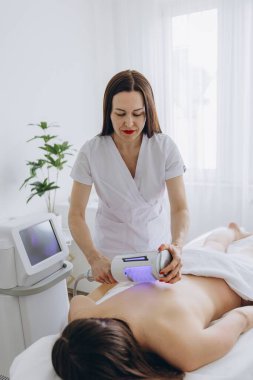 Kozmetik uzmanı kadının sırtında endosfer tedavisi uyguluyor. Selülit önleyici masaj, figür düzeltme lenfatik drenaj, güzellik kliniğinde müdahale edilmeyen tedavi. Yüksek kalite fotoğraf