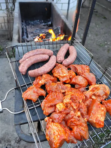Meat, sausages, beef, pork, chicken, sausages, home cooking, barbecue, meat marinated in sauce, steaks, red sauce are cooked on the grill