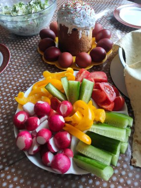 Sebzeli Paskalya vejetaryeni öğle yemeği: turp, salatalık, domates, biber. Yumurta boyamak ve paskalya pastası. Tablo ayarı