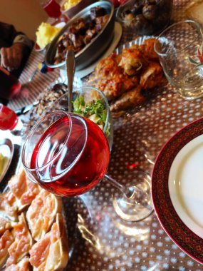 Bardakta şarap ve geleneksel yemeklerle şenlik masası.