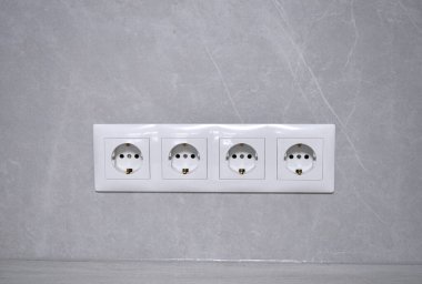 Beyaz prizler bloğu, 220, 110 volt, gri bir duvara elektrik.