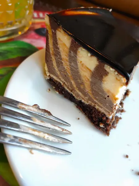 piece of vanilla chocolate zebra cake, on a plate and fork