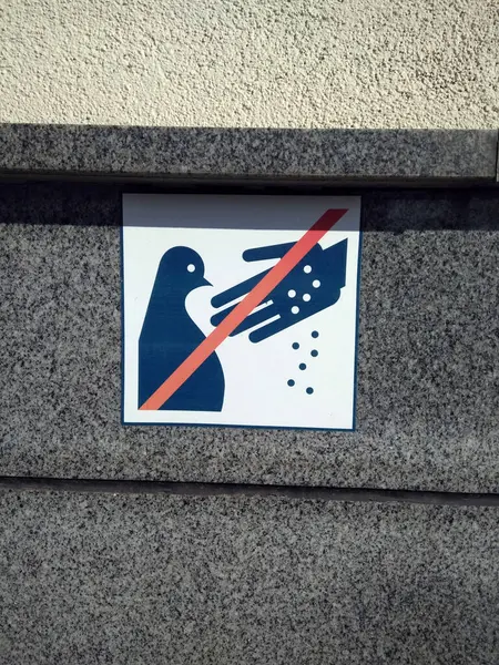 sign on the wall do not feed pigeons, directional sign, warning sign about the prohibition of feeding birds