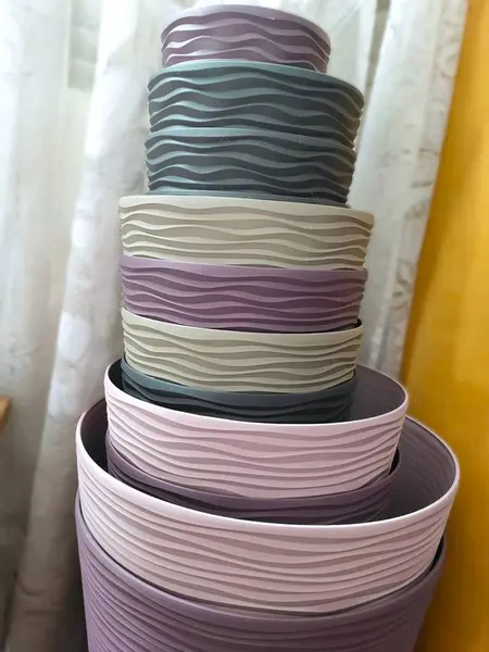 Pastel renklerin saksıları bir yığın halinde duruyor.