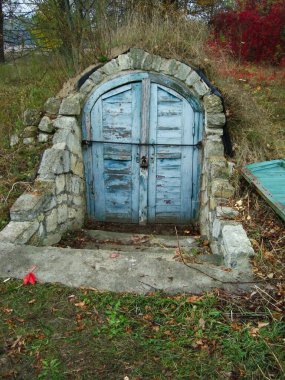 Bodrum ya da mahzene açılan mavi kapısı olan bir giriş. Yeraltı evi, hobbit evi.,