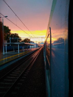 Tren penceresinden gün doğumunda, gün batımında, platformda, tren istasyonunda, tren yolu boyunca seyahat et.
