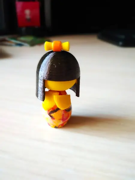 Küçük oyuncak Kokeshi bebek, Japon oyuncak, sarı. Kimonolu bebek. Yakın plan.