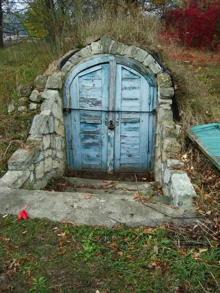 Bodrum ya da mahzene açılan mavi kapısı olan bir giriş. Yeraltı evi, hobbit evi.,