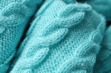 Makro yakın plan: zarif turkuaz örülmüş kumaş, örülmüş bir deseni andıran görünür dikişler. Yan görünüm: açısal bakış açısı, mavi, yeşil, iplik, örgü, kumaş dokusu