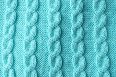 Makro yakın plan: örülmüş deseni andıran görünür dikişli narin turkuaz kumaş. Üst manzara mavi, yeşil