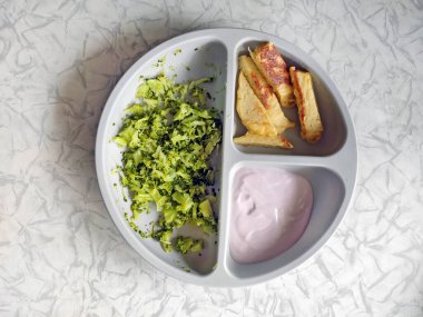 İlk bebek maması, tamamlayıcı yiyecekler, püre, bebek tabağı, masada gri tabak ve kaşık, bebek yoğurdu için yemek, yeşil salata, krep,