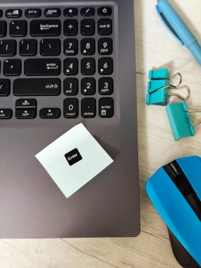 Laptoplu iş yeri, mavi kablosuz fare, zarflar, defter, ofis masası, ahşap masadaki yapışkan notlar. İş, planlama, uzaktan çalışma konsepti, serbest çalışma, eğitim