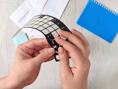 Eller dizüstü bilgisayara klavye çıkartması takıyor. Klavye özelleştirme ve koruma için esnek dizüstü bilgisayar etiketi. Kağıt ve defter ile modern çalışma alanı arkaplanı. Minimalist teknoloji kavramı. Serbest ticaret.