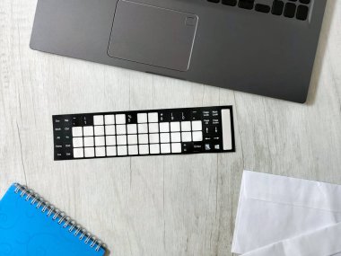 Bilgisayarlı, zarflı, defterli, ofis masalı, hafif ahşap bir masanın üzerinde. İş, planlama, uzaktan çalışma konsepti, serbest çalışma, klavye için çıkartma