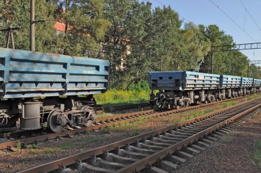 Yazın tren raylarında mavi yük vagonları. Malların taşınması için metal konteynırlar taşıyan endüstriyel kargo treni..