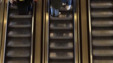 Metro 'daki ağaç yürüyen merdivenler insanları metro istasyonuna götürüp getiriyor. Yolcular hareket halindeki merdivenlerde duruyorlar. Video klibini döndür. Yukarıdan görüntüle.