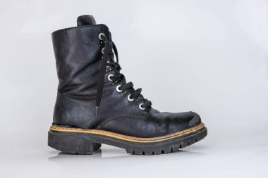 Eski, kırık, siyah, deri, dantelli botlar. Moda sonbahar çizmeleri. Şık kadınların erkek üniformaları. Ayakkabı bağcıklı Grunge botları. Beyaz arka planda izole edilmiş yüksek askeri ayakkabılar. Düz yatıyordu. Boşluğu kopyala