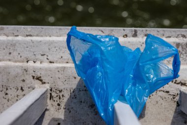 Blue Plastic bag hanging on the railing of Elisabeth bridge over Donau river in Budapest. Garbage in the city. Environmental pollution concept. Ecological disaster, catastrophe. Selective focus clipart