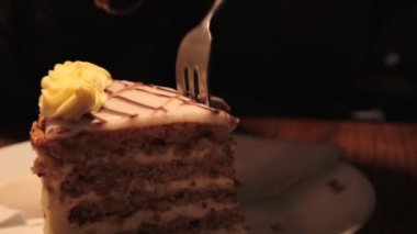 Lezzetli ev yapımı lezzetli, fındık ve kremalı Esterhazy keki. Esterhazy Torte 'nin bir parçası beyaz tabakta peçeteyle servis edildi. Birisi pastayı yiyor, çatalla bir parça alıyor..