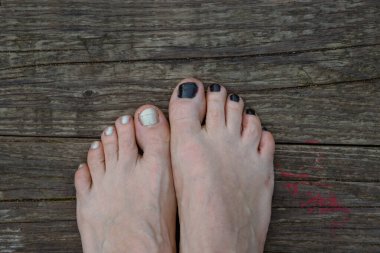 Suyun üzerinde çıplak ayaklı beyaz inci tırnak cilası asılı. Gölde dinleniyor, nehir kıyısında oturuyor. Doğada dinlenmek. Gökyüzü yansıması. Tatil havası. Mutlu yaz günleri. Üst görünüm