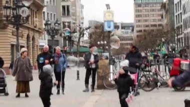 Frankfurt am Main, Hessen, Almanya. 24 Şubat 2023. Adam kordon halkasıyla dev renkli sabun köpüğü gösterisi yapıyor. Mutlu çocuklar gülüyor ve koşuyor, baloncukları yakalayıp patlatmaya çalışıyorlar.