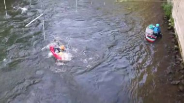 Bamberg, Bavyera, Almanya, 16 Ağustos 2022. Eski Belediye binasının yanındaki Regnitz Nehri 'nde kayakçılar yarışması. Altes Rathaus 'un yanındaki derede kayak yapan bir grup insan. Kano slalom. Üst görünüm.