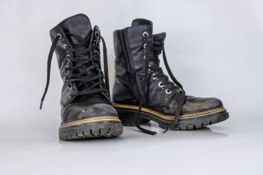 Eski, kırık, siyah, deri, dantelli botlar. Moda sonbahar çizmeleri. Şık kadınların erkek üniformaları. Ayakkabı bağcıklı Grunge botları. Beyaz arka planda izole edilmiş yüksek askeri ayakkabılar. Düz yatıyordu. Boşluğu kopyala