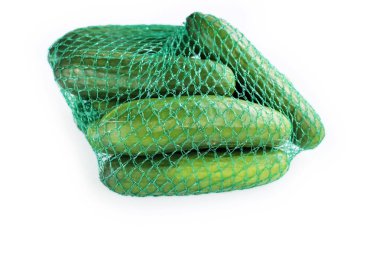Yeşil plastik ağ örgü torbasında bir yığın yeşil salatalık. Beyaz arka planda izole edilmiş. Mesaj için yer var. Uzayı kopyala Yakın plan. Üst görünüm