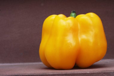 Kahverengi ev basamağında yeşil saplı Büyük Sarı Paprika Tatlı Biber