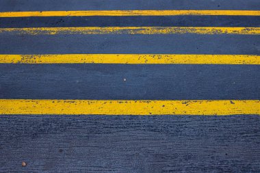 Kalıplı asfalt bir yola yakın, pürüzlü gri bir kaldırım üzerinde aşınmış sarı çizgiler, sokak fotoğrafçılığı, kentsel tasarım ya da trafik bağlantılı görsellerde kullanım için harika. Boşluğu kopyala