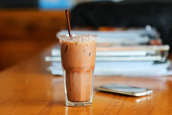 Iced Chocolate with mobile phone and books behind