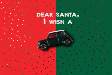 Sevgili Noel Baba, yeşil ve kırmızı parıltılı arka planda yeşil oyuncak arabalı bir yılbaşı düzeni istiyorum. Noel konsepti.