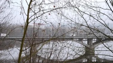 Arabalar kışın nehir boyunca şehir köprüsü boyunca yol alırlar. Yüksek kaliteli FullHD görüntüler