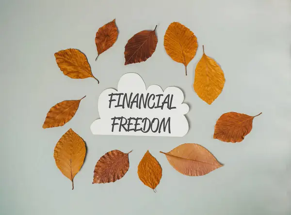 A circle of leaves with the word financial freedom written in the center. The leaves are scattered around the circle, with some overlapping and others placed in different positions