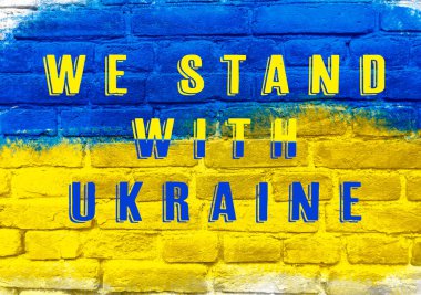 Üzerinde Ukrayna 'nın yazılı olduğu mavi ve sarı bir duvar. Duvarın renkleri ve metin Ukrayna için bir birlik ve destek duygusu yaratıyor