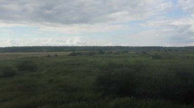 Ön planda direği olan bulanık bir alan görüntüsü. Sahne sakin ve huzurlu, engin açık alan ve gökyüzü