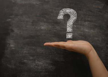 Üzerinde soru işareti olan bir tahtayı tutan bir el. Kara arka planda kara tahta var.