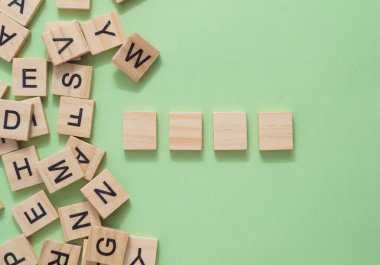 Tahta harfler yığını. Harfler görüntüye dağılmış, bazıları birbiriyle örtüşüyor. Sahne düzensizlik ve karmaşadan ibarettir.