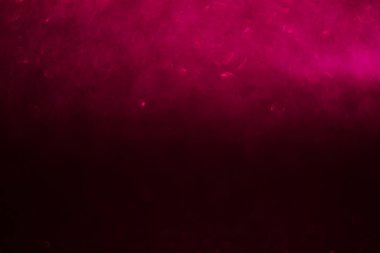 Ön planda bulanık pembe bir nesne olan pembe bir arkaplan. Arka plan karanlık ve nesne bulanık hareket ve enerji izlenimi veriyor.