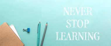 Öğrenmeyi asla bırakma. Bu, insanları hayatları boyunca öğrenmeye ve büyümeye teşvik eden motive edici bir mesaj. Üzerinde mavi ve gri bir kalem ve kalem olan yeşil bir arka plan.