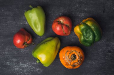 Bir tezgahta bir grup biber ve domates sergileniyor. Sebzelerin düzenlenmesi renkli bir şekil yaratır. Çirkin sebzeler, yiyecek organik atık azaltma