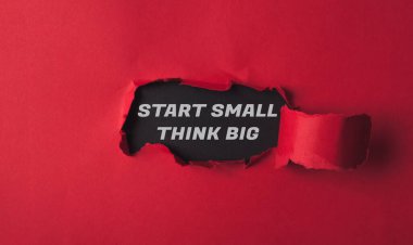 Red background with a black word that says start small think big written in white. The image has a mood of determination and motivation clipart