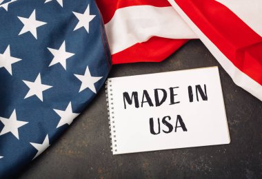 Amerikan yapımı beyaz bir kağıt parçasına yazılmıştır. Kağıt kırmızı, beyaz ve mavi bir Amerikan bayrağının üzerine konur.