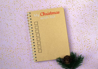 Spiral bound notebook with a Christmas wish list written on it. The notebook is placed on a purple background with a pine cone on top of it clipart