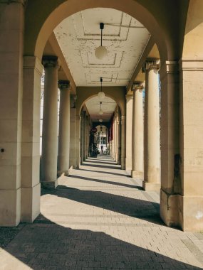 Karlsruhe, Almanya - 21 Mart 2022 - Sütunları ve üzerinde bir ışık parlayan uzun bir koridor. Işık yere gölge düşürüyor.